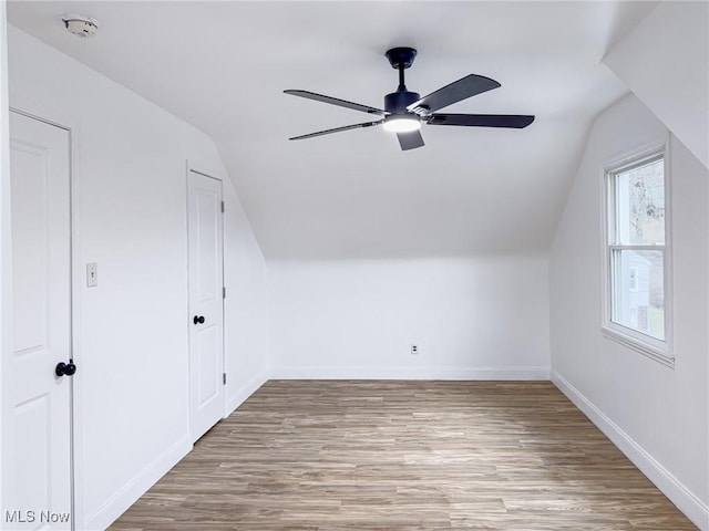 bonus room with ceiling fan, baseboards, vaulted ceiling, and wood finished floors