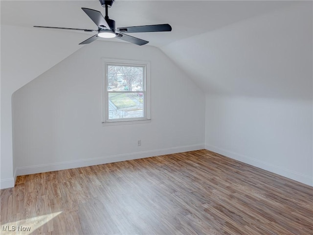 additional living space featuring lofted ceiling, light wood-style flooring, and baseboards