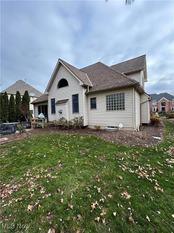 view of front of property with roof with shingles and a front yard