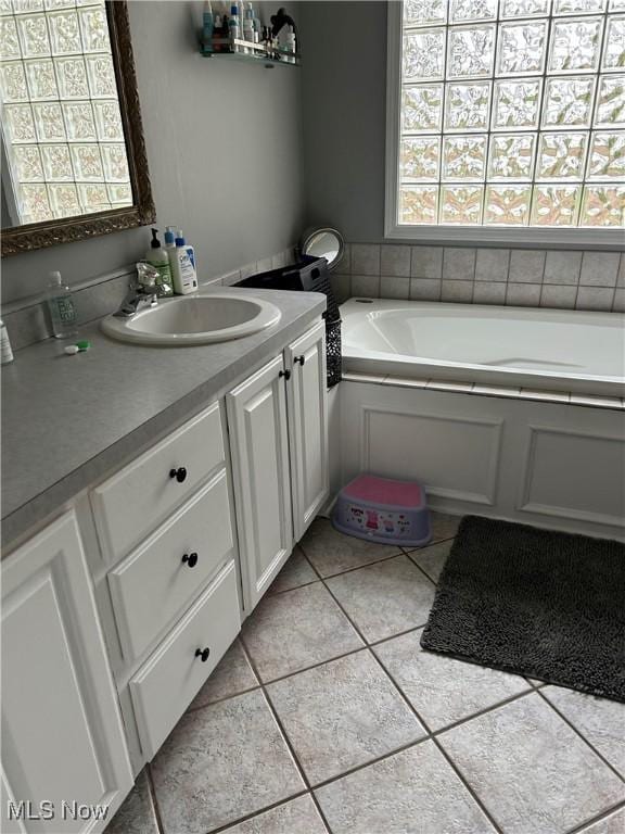 full bath with vanity, a bath, and tile patterned floors