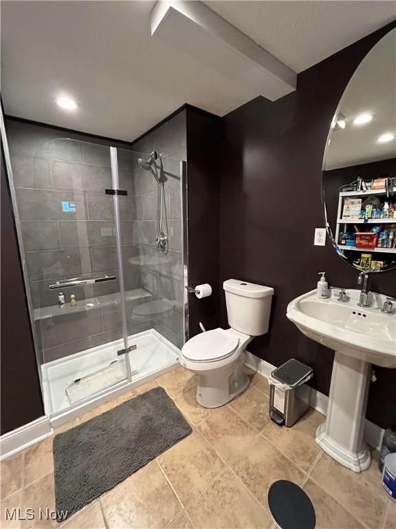 full bath featuring baseboards, a shower stall, and toilet