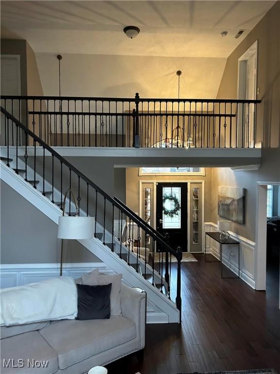 entryway featuring a towering ceiling, stairway, and hardwood / wood-style floors