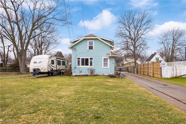 back of property with fence and a yard