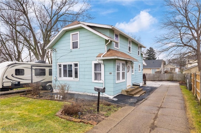 view of front facade featuring entry steps, fence, and a front yard