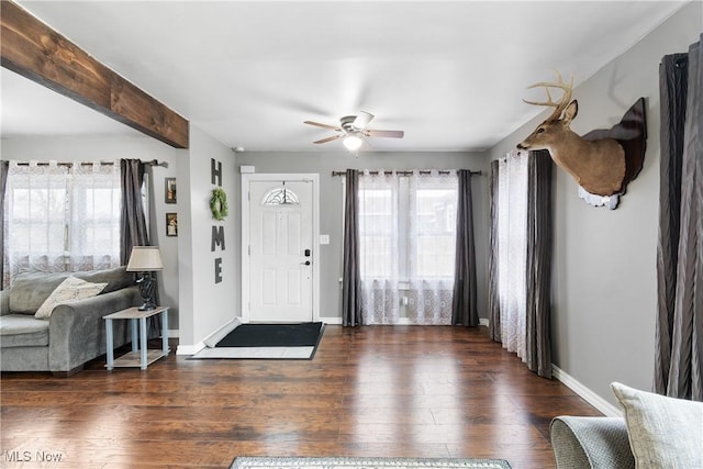 entrance foyer with beamed ceiling, wood finished floors, a wealth of natural light, and baseboards