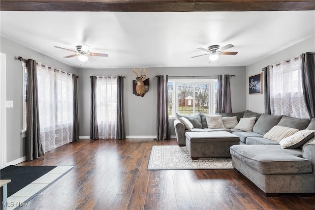 living area featuring a ceiling fan, dark wood finished floors, and baseboards