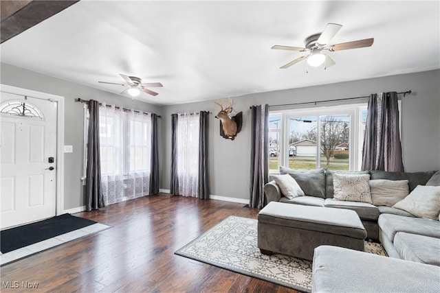 living area with baseboards, plenty of natural light, a ceiling fan, and wood finished floors