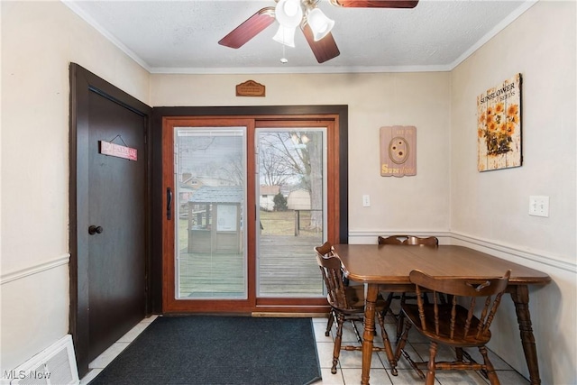 dining space with ornamental molding, visible vents, ceiling fan, and a textured ceiling