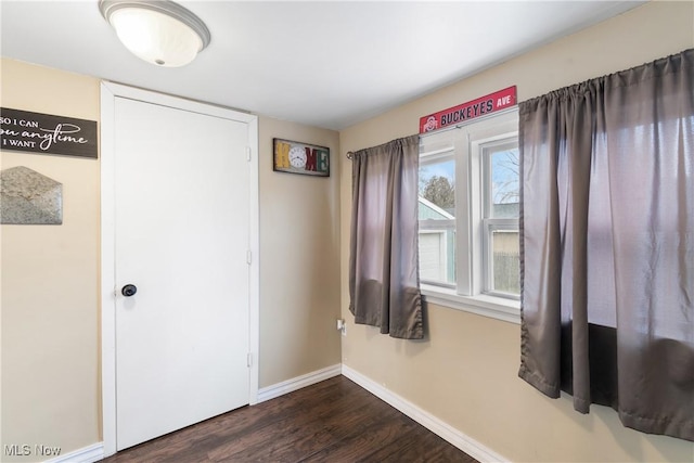 unfurnished bedroom featuring dark wood-style floors and baseboards