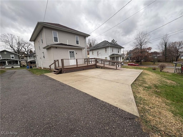 rear view of house with a deck and a yard