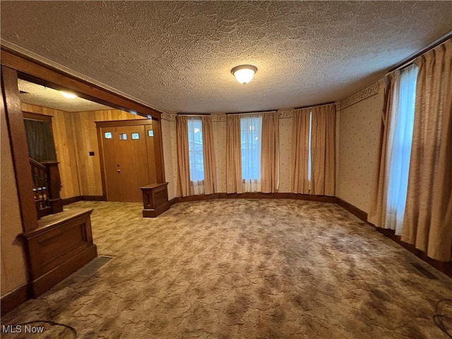 entryway with carpet floors, stairway, a textured ceiling, and baseboards