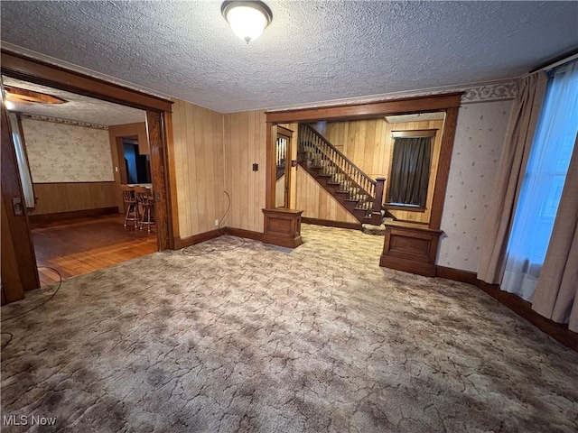 interior space featuring stairs, carpet, a textured ceiling, and wallpapered walls