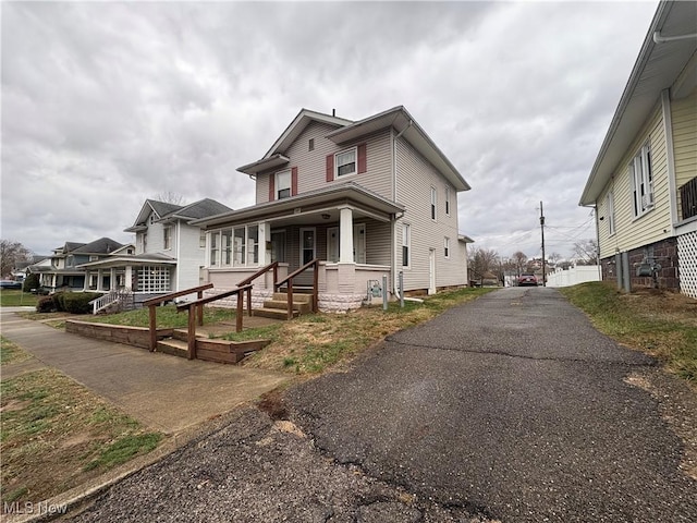 american foursquare style home featuring a porch