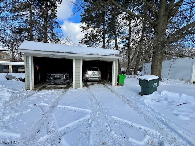 snow covered garage featuring a detached garage