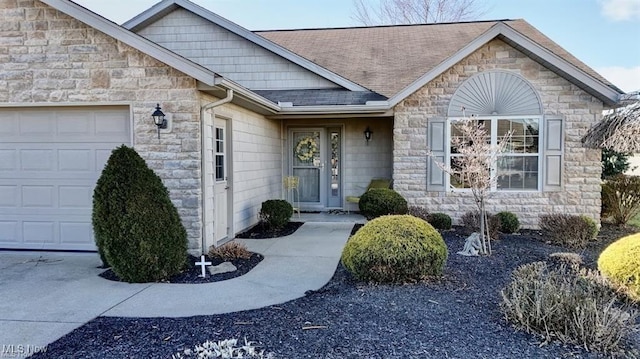 doorway to property with a garage, stone siding, and roof with shingles