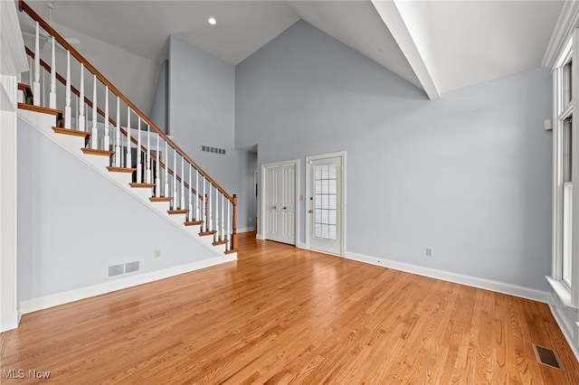 interior space featuring light wood-style floors, baseboards, stairs, and visible vents