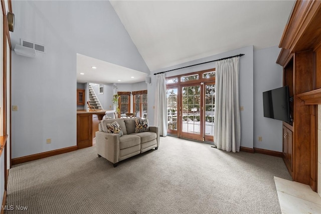 living room with light carpet, stairway, visible vents, and high vaulted ceiling