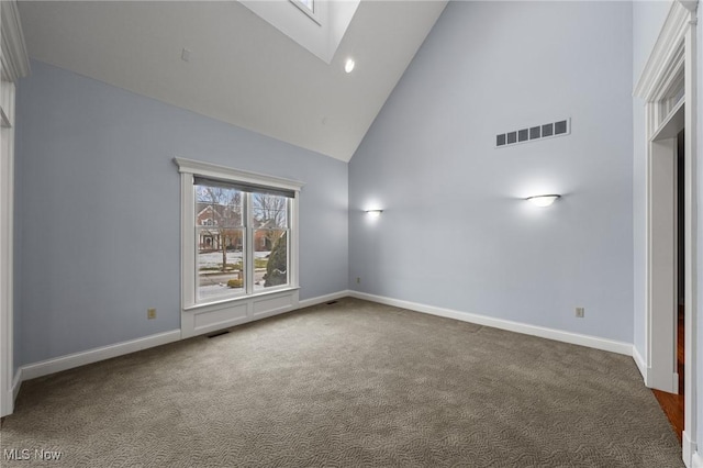 empty room featuring carpet floors, visible vents, high vaulted ceiling, and baseboards