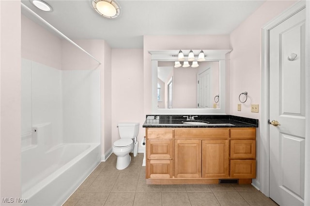 bathroom featuring toilet, vanity, baseboards, tub / shower combination, and tile patterned floors