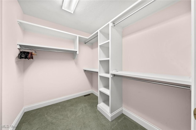 walk in closet featuring visible vents and dark carpet