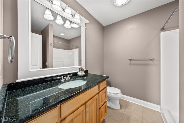 bathroom featuring baseboards, toilet, tile patterned flooring, walk in shower, and vanity