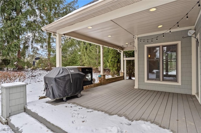 snow covered deck featuring a grill