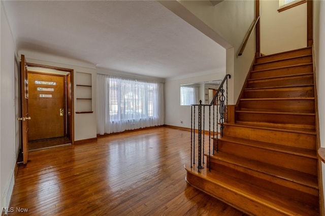 entryway featuring stairs, wood finished floors, and baseboards