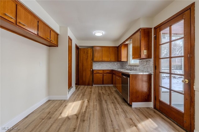 kitchen with backsplash, brown cabinetry, dishwasher, and light wood finished floors