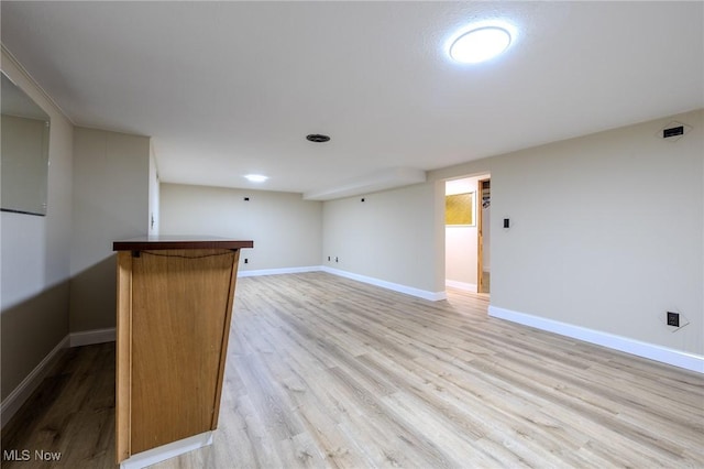 empty room with light wood finished floors and baseboards