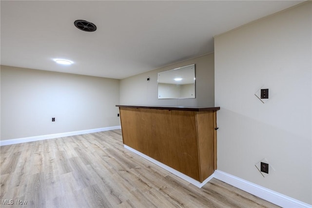 bar featuring light wood-style floors and baseboards