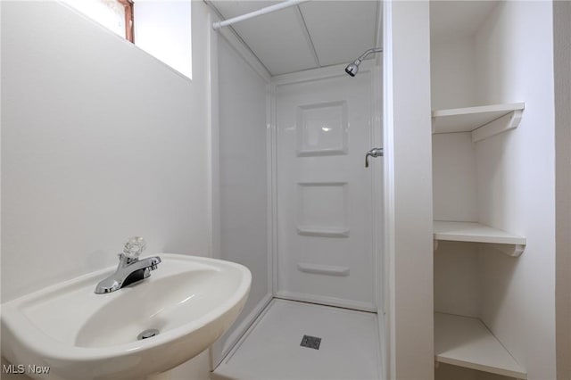 full bath featuring a sink and a shower stall