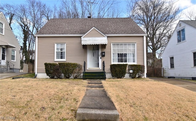 view of front of house featuring roof with shingles and a front yard