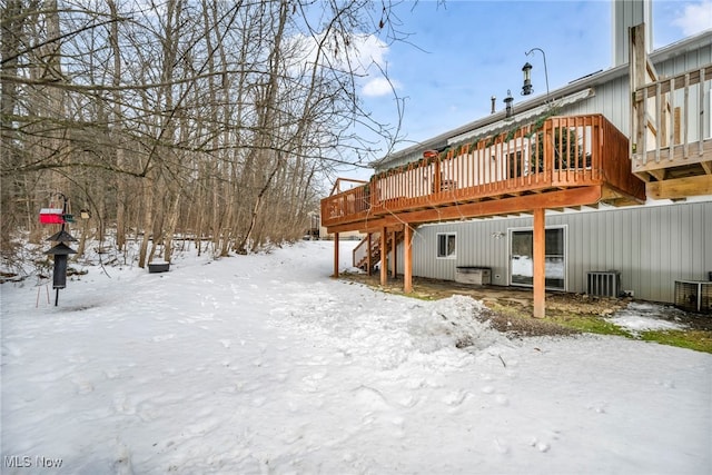 snow covered rear of property featuring a deck, central AC, and stairs