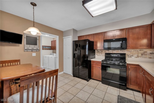 kitchen with black appliances, washing machine and dryer, decorative backsplash, and brown cabinetry