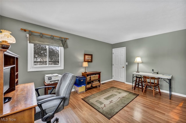 office space featuring baseboards and wood finished floors