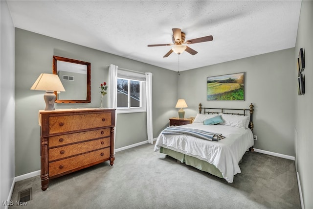 carpeted bedroom with visible vents, a textured ceiling, and baseboards