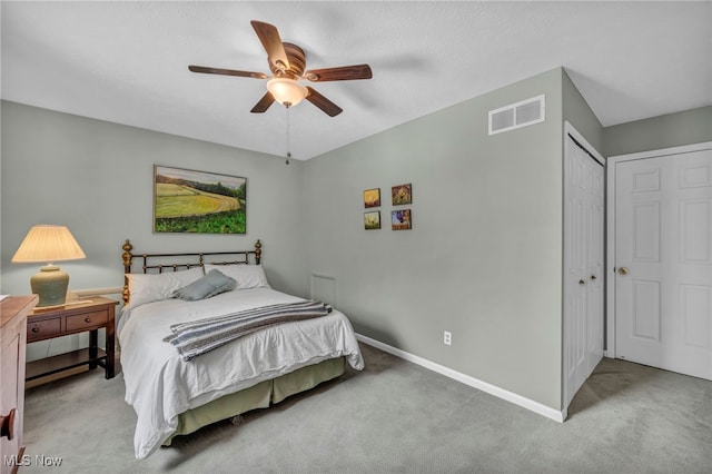 carpeted bedroom featuring a closet, visible vents, ceiling fan, and baseboards