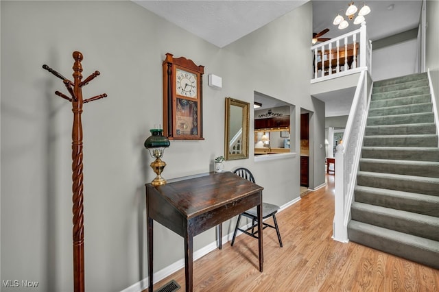 interior space with light wood finished floors, visible vents, ceiling fan, a textured ceiling, and baseboards