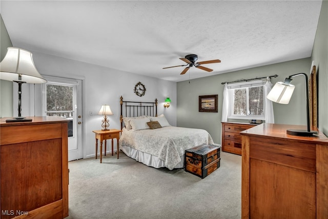 bedroom with light carpet, ceiling fan, and a textured ceiling