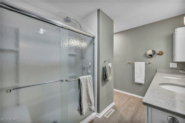 bathroom featuring a shower stall, visible vents, and a sink