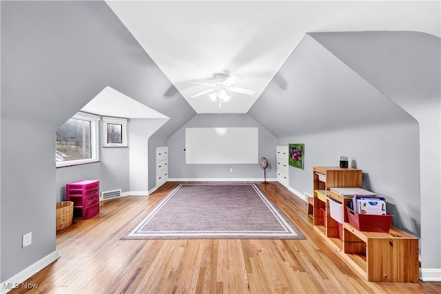 bonus room with lofted ceiling, visible vents, hardwood / wood-style floors, a ceiling fan, and baseboards