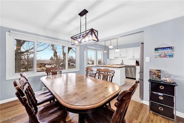 dining area featuring baseboards and light wood finished floors