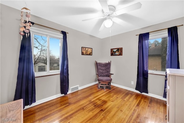 unfurnished room featuring baseboards, a wealth of natural light, visible vents, and light wood-style floors