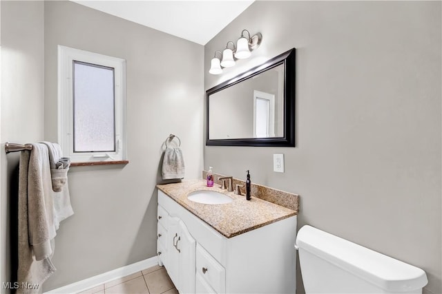 bathroom featuring tile patterned flooring, baseboards, vanity, and toilet