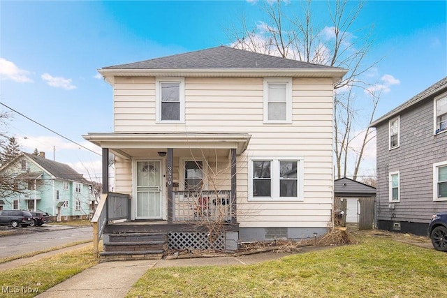 traditional style home featuring covered porch, crawl space, roof with shingles, and a front yard