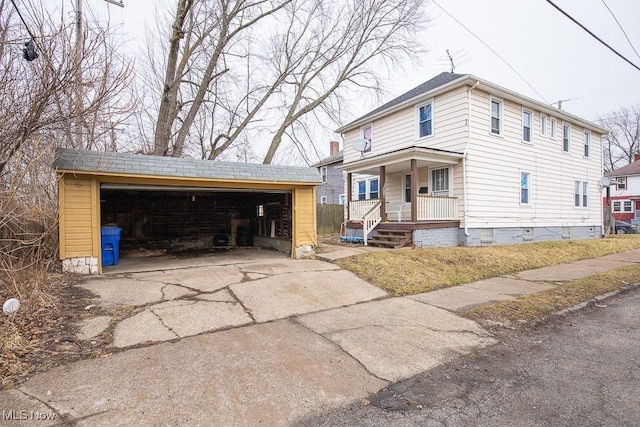 view of front of house with a garage, a porch, and an outdoor structure