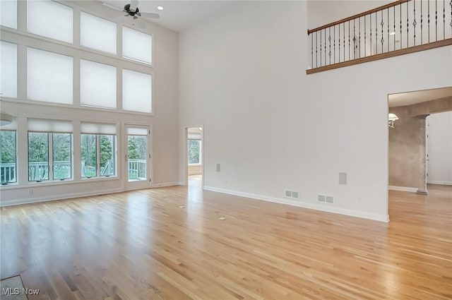 unfurnished living room with light wood-style floors, baseboards, and visible vents