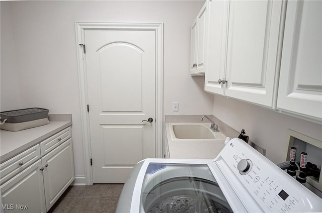 laundry room featuring cabinet space, a sink, and tile patterned floors