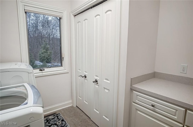 clothes washing area featuring washer / dryer, laundry area, and baseboards