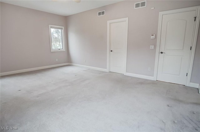 unfurnished bedroom featuring baseboards, visible vents, and light colored carpet